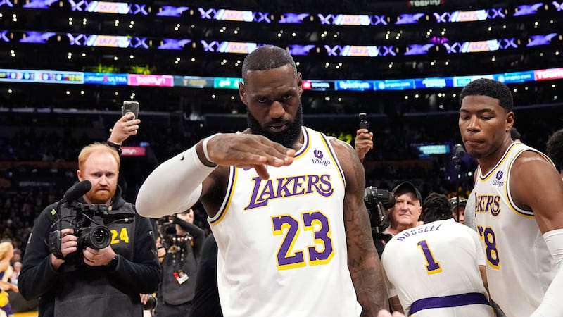 FILE - Los Angeles Lakers forward LeBron James salutes public address announcer Lawrence...