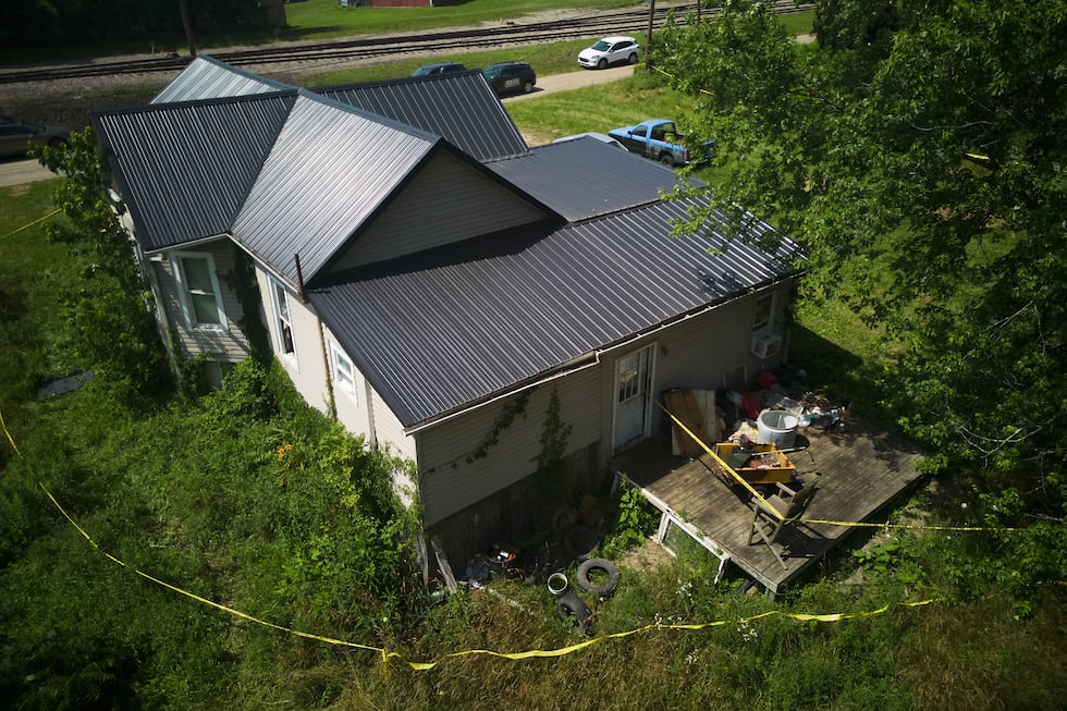 Police tape surrounds a home where authorities say they removed 16 children and arrested four...