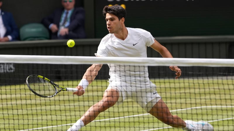 Carlos Alcaraz of Spain plays a forehand return to Novak Djokovic of Serbia during the men's...