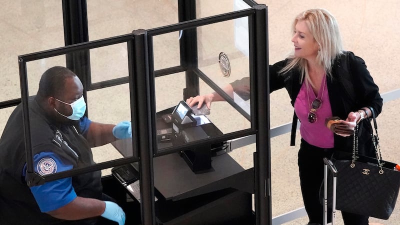 FILE - A traveler makes their way through a security ID and ticket check at Love Filed in...