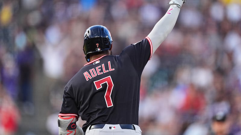 Cleveland Guardians' Jo Adell gestures to the bullpen as he circles tha bases after hitting a...