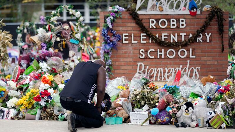 FILE - Reggie Daniels pays his respects at a memorial at Robb Elementary School in Uvalde,...