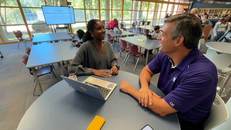 Marietta City Schools Superintendent Dr. Grant Rivera talks with a senior at Marietta High...