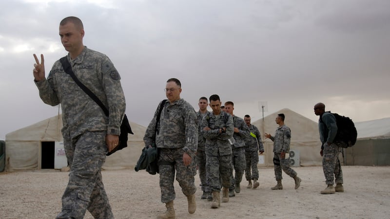 FILE - A U.S. army soldier flashes a V for victory sign as he begins his journey home at the...