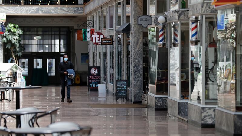 FILE - In this May 7, 2020 file photo, a man walks through the 5th Street Arcade, a selection...