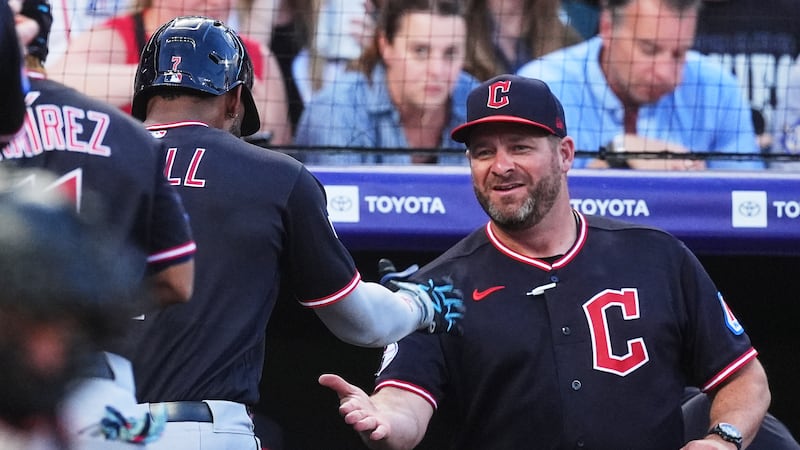 Cleveland Guardians manager Stephen Vogt, right, congratulates Jo Adell who returns to the...