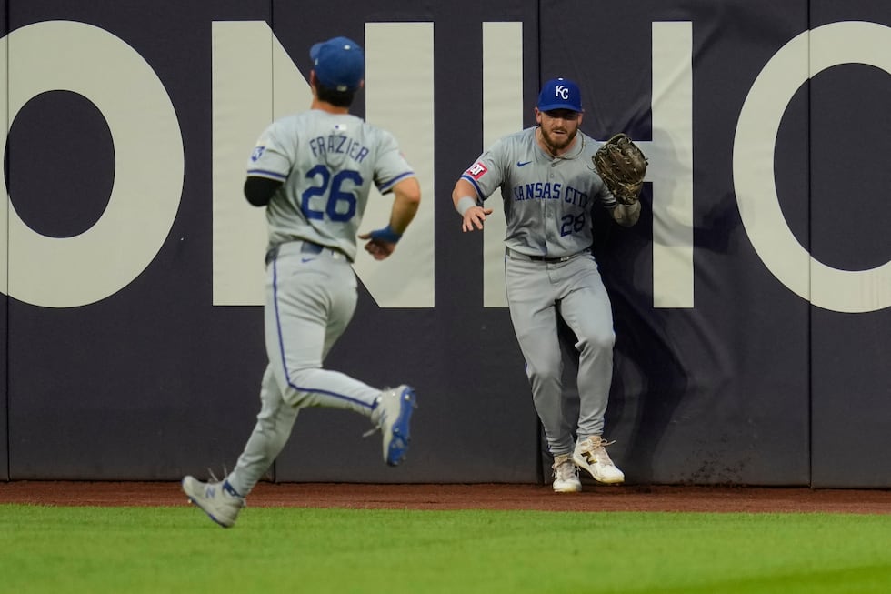 Kansas City Royals center fielder Kyle Isbel (28) crashes into the outfield wall behind...