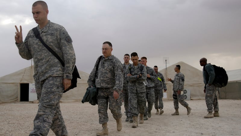 FILE - A U.S. army soldier flashes a V for victory sign as he begins his journey home at the...