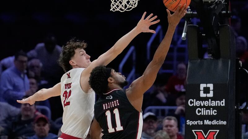 Massachusetts' Jayden Ndjigue (11) shoots as Miami forward Brant Byers (22) defends in the...